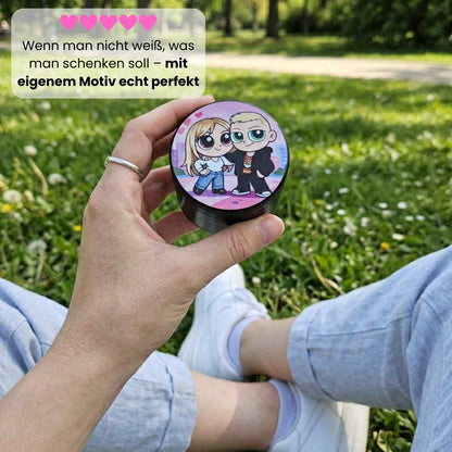 Personalisierter schwarzer, personalisierter Grinder aus Aluminium in der Hand einer Frau im Park 